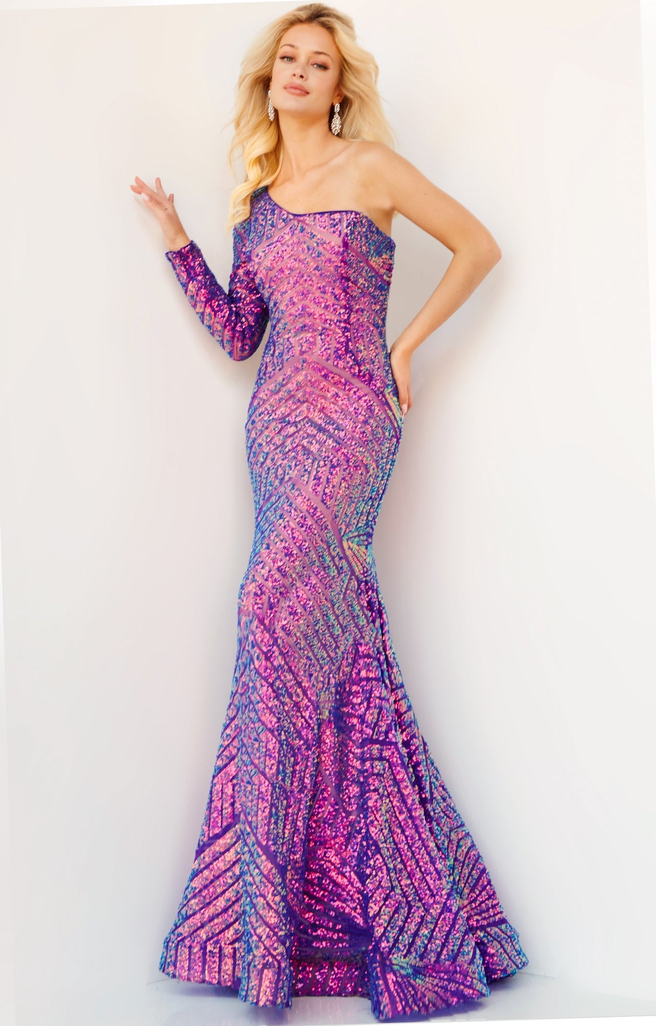 A woman poses in a fitted, floor-length Jovani Violet Purple Prom Dress with one long sleeve and sequin detailing, showcasing a chic style against a plain light background.